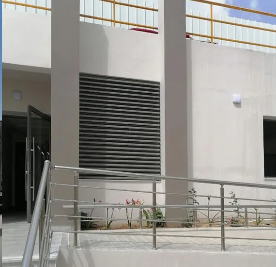 Brise-soleil fixe en aluminium sur mur extérieur, assurant protection solaire et ventilation, réalisé par Alusystem Tunisie