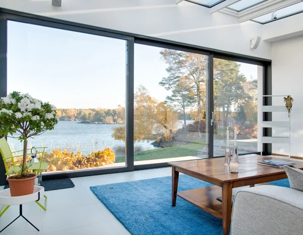 Intérieur d'une villa moderne en Tunisie avec une grande baie vitrée en aluminium, illustrant un projet de menuiserie bien budgétisé en 2025