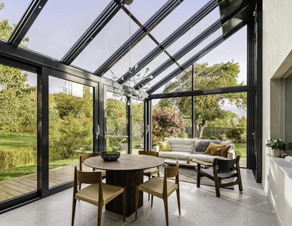 Véranda Aluminium Tunisie : Comparatif Modèles et Prix 2026 Modèle de véranda en aluminium sur mesure pour une villa en Tunisie, illustrant une extension de maison moderne avec toiture vitrée et isolation thermique